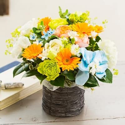 グリーンやブルー、オレンジ、ピンクとカラフルなバラとトルコギキョウのミックスアレンジ