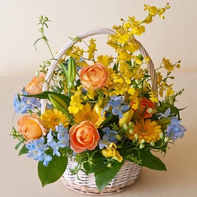 黄色、オレンジ、ブルーで彩られた華やかなフラワーバスケット