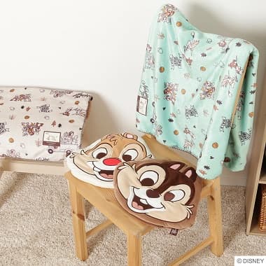 椅子の背もたれにかけられたブランケットと椅子に置かれたクッション