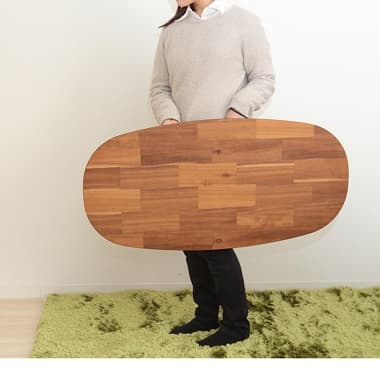 折りたたんだ折れ脚テーブルを両手で運ぶ女性