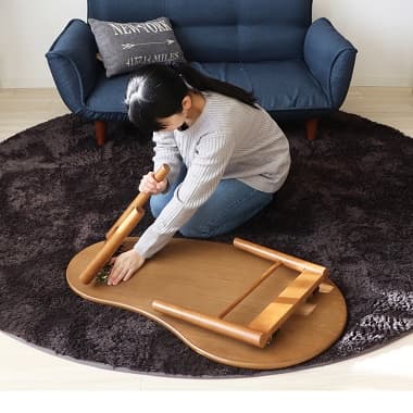 折れ脚テーブル(豆型)を折りたたむ女性