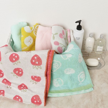 化粧品と共にカゴに入れられたフルーツ無撚糸フェイスタオル