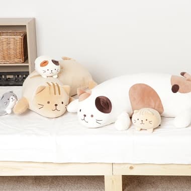 ベッドの上に置かれた2つの抱き枕と3つのマスコット