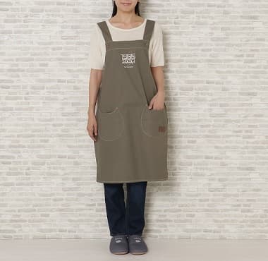 カーキ色のキャンバスワークエプロンを付けた女性