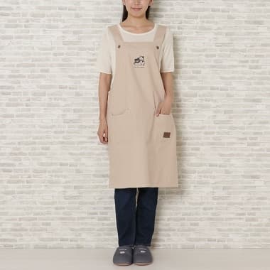 ベージュ色のキャンバスワークエプロンを付けた女性