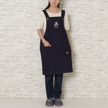 ネイビー色のキャンバスワークエプロンを付けた女性