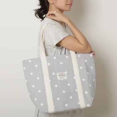 スター柄 保冷保温キャンバストートバッグを背負う女性