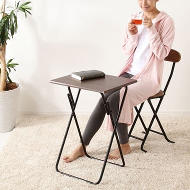 ウッド風おりたたみテーブルでちょっとした作業をする女性