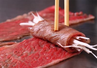 切り落としの肉を焼いて白ネギをまいているイメージ