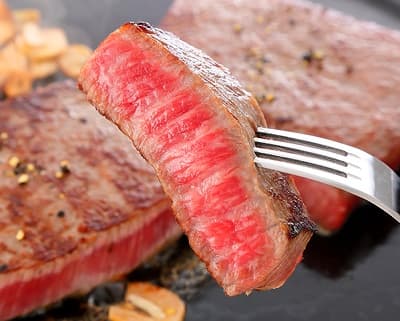 中は赤いレアの神戸牛ステーキの切り身をフォークで刺して取り上げた所