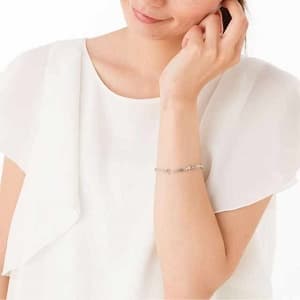 左腕にPair-bracelet テンプル クロスを嵌めた女性