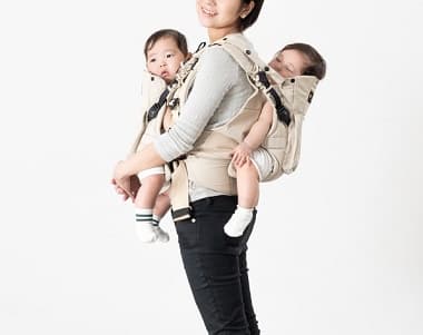 ふたご抱っこひもで抱っことおんぶをする母親