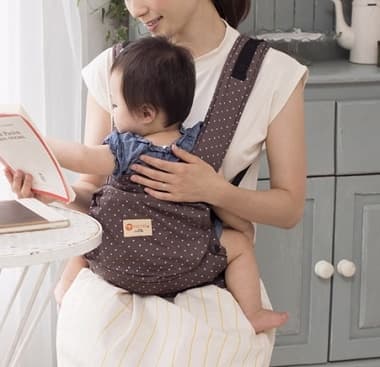抱っこ紐で赤ちゃんを抱っこする母親