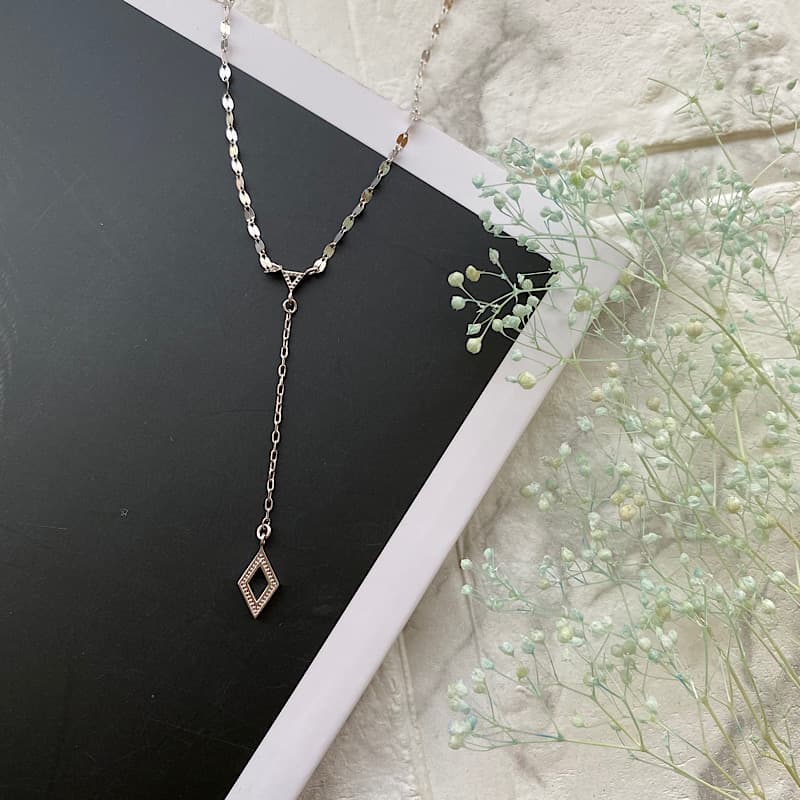 黒いテーブルに置かれたスイフマン ネックレス