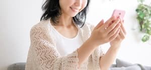 スマホにソーシャルでギフトが届いて喜ぶ女性